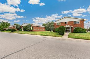 Lakewood apartment for rent - A red brick house with a white door and windows.