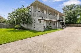 Beaumont apartment for rent - A two-story building with a balcony and a staircase leading to the second floor.