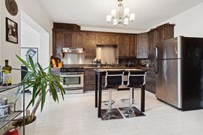 Montréal apartment for rent - A kitchen with a black fridge and a black table with four chairs.