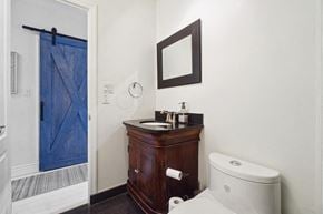 Montréal apartment for rent - A bathroom with a toilet, sink, and mirror.