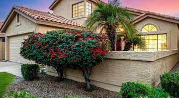Tempe house for rent - A house with a red roof and a tree with red flowers in front.