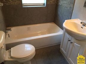 Clinton house for rent - A white toilet sits next to a bathtub in a bathroom.