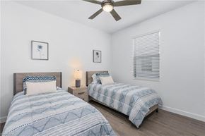 Estero house for rent - A bedroom with two beds and a ceiling fan.