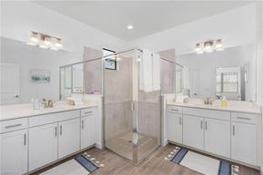 Estero house for rent - A bathroom with a walk-in shower and double sinks.