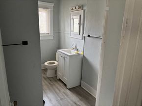 Akron apartment for rent - A bathroom with a toilet, sink, and medicine cabinet.