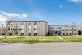 Welland apartment for rent - Apartment building with a blue sky and clouds in the background.