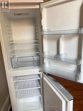 Barrie (City Centre) multi-family for rent - A white refrigerator with the door open and shelves inside.