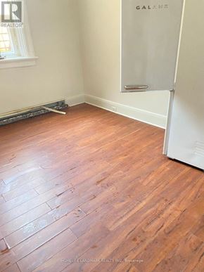 Barrie (City Centre) multi-family for rent - A room with wooden flooring and a white door.