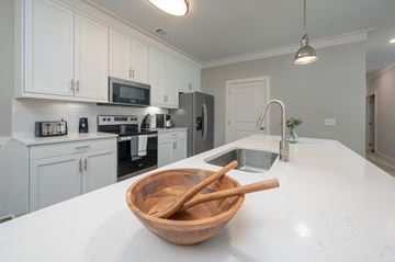 Columbus apartment for rent - A kitchen with white cabinets and a wooden bowl on the counter.