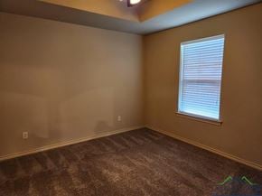 Longview apartment for rent - A room with a carpeted floor and a window with blinds.