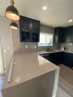 San Diego house for rent - A kitchen with a countertop and black cabinets.