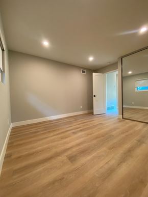 San Diego house for rent - A room with wooden flooring and a mirror on the wall.
