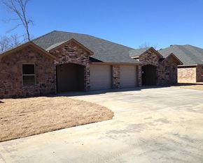 Longview apartment for rent - A house with a grey roof and stone exterior with a driveway in front.