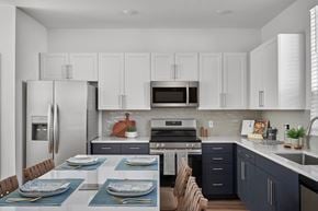 Hutto apartment for rent - A modern kitchen with a dining table set for two.