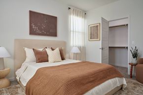Hutto apartment for rent - A bedroom with a large bed and a brown blanket.