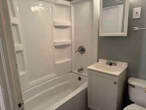 Rockford apartment for rent - A white bathroom with a toilet, sink, and bathtub.