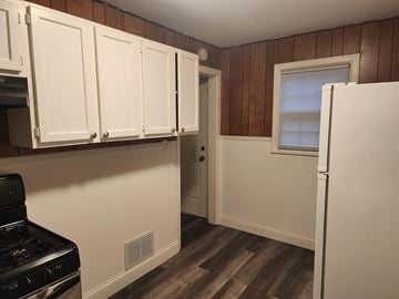 Rockford house for rent - A kitchen with white cabinets and a black stove top oven.