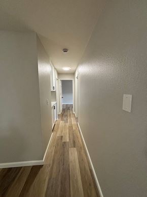 San Diego apartment for rent - A long hallway with wood floors and white walls.