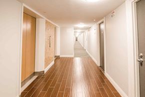London apartment for rent - A long hallway with brown tile floors and white walls.