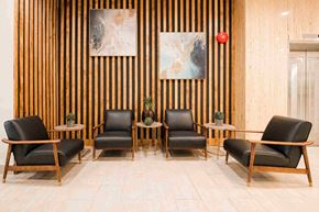 London apartment for rent - Four black leather chairs are arranged in a row.