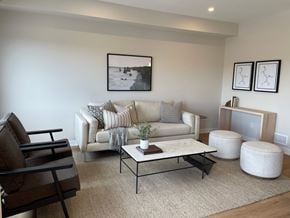 Kanata apartment for rent - A living room with a white couch, a coffee table, and a chair.