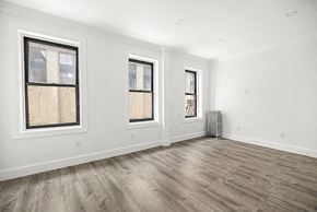 New York apartment for rent - A room with two windows and a radiator on the wall.