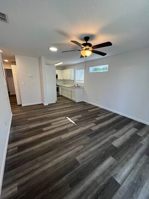 St. Augustine apartment for rent - A room with a ceiling fan and wooden flooring.