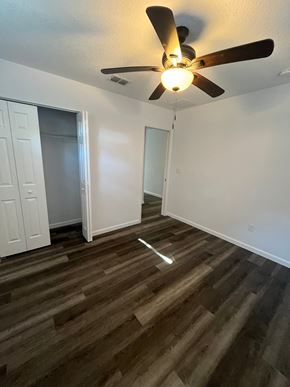 St. Augustine apartment for rent - A room with a ceiling fan and wooden flooring.
