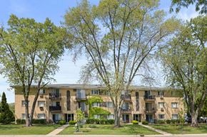 Wheaton apartment for rent - A large apartment building with balconies and trees in front.