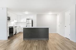 Wheaton apartment for rent - A kitchen with a black countertop and wooden floors.