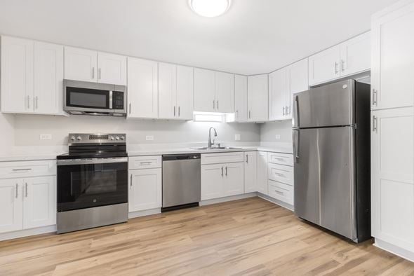 Wheaton apartment for rent - A kitchen with white cabinets and stainless steel appliances.