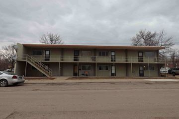 Great Falls apartment for rent - A parking lot with a building in the background.
