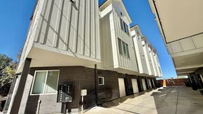 Denver apartment for rent - A modern kitchen with a white countertop and wooden cabinets.