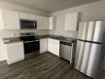 Rocky Mount house for rent - A kitchen with white cabinets and stainless steel appliances.