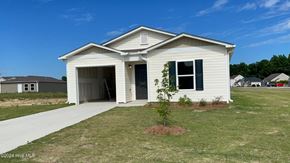 Rocky Mount house for rent - A small white house with a garage door open and a tree in front of it.