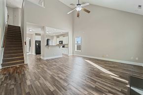 Jacksonville house for rent - A spacious room with wooden flooring and a ceiling fan.