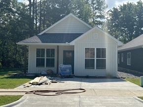 Little Rock house for rent - A house with a grey roof and white walls is surrounded by trees.