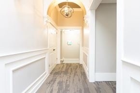 Pembroke apartment for rent - A hallway with a chandelier and a door at the end.