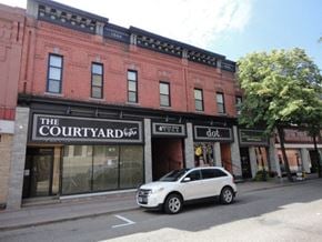 Pembroke apartment for rent - A white car is parked in front of a red building with a sign that says "The Courtyard".