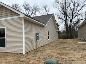 Benton house for rent - A small house with a brown roof and a grey garage door.