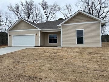 Benton house for rent - A two-story house with a garage is situated in a field.