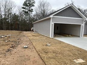 Benton house for rent - A garage with a grey roof is situated in a yard with a dirt path leading to it.