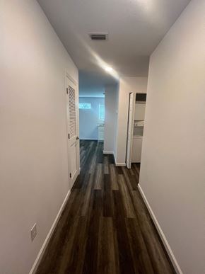 St. Augustine apartment for rent - A long hallway with wood floors and white walls.