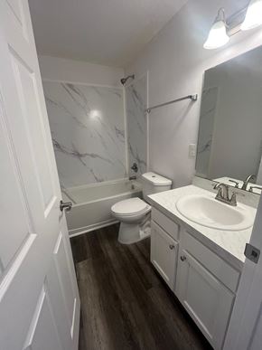 St. Augustine apartment for rent - A white bathroom with a marble wall and wood flooring.