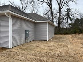 Benton house for rent - A metal garage door is closed and the garage is white.