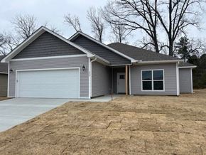 Benton house for rent - A grey house with a white garage door and a brown driveway.