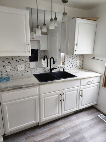 Cleveland house for rent - A kitchen with white cabinets and a black sink.