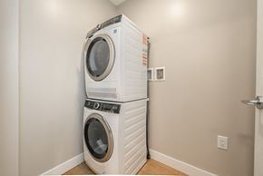 Victoria apartment for rent - Two white front load washing machines stacked on top of each other in a laundry room.