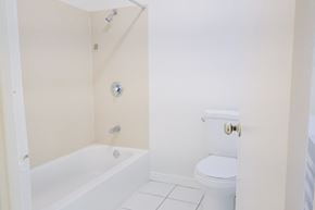 Oakland apartment for rent - A white bathroom with a toilet and a bathtub.