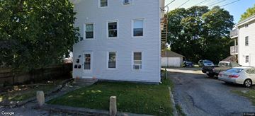 Pawcatuck apartment for rent - A white house with a green lawn in front.